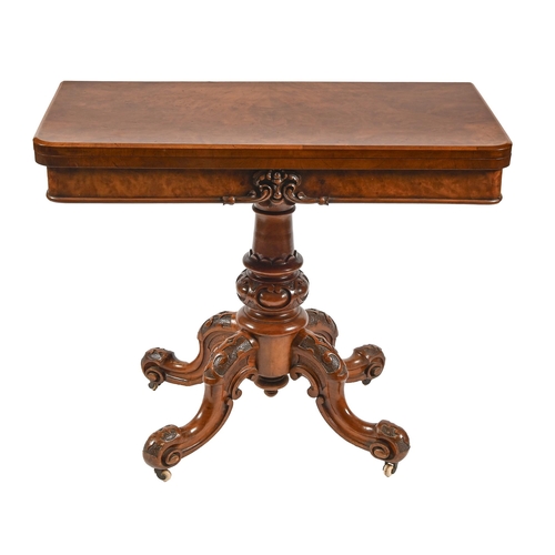 667 - A Victorian walnut card table, the fold-over baize lined top in matched butterfly veneers, on carved... 