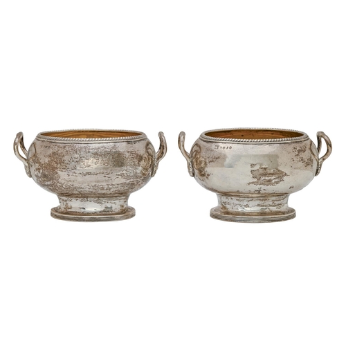 429 - A pair of George III silver cream bowls, oval shaped with gadrooned rim, the loop handles with leaf ... 