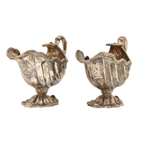 432 - A pair of George II rococo silver sauceboats, shell shaped with gadrooned rim and leaf capped scaly ... 