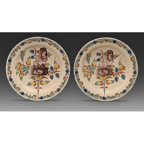 556 - A pair of Dutch Delftware dishes, 19th c, painted in polychrome with stylised flowers in trailing bo... 