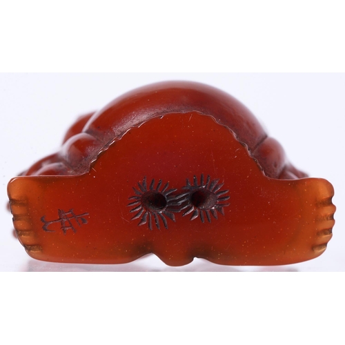 708 - An amber netsuke of a sumo wrestler, signed, 4.5 x 4.5cm