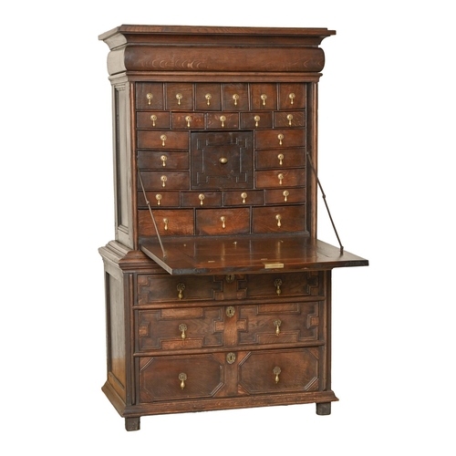 970 - An oak escritoire, late 18th c, in Jacobean style, the lower part with three drawers of geometric de... 