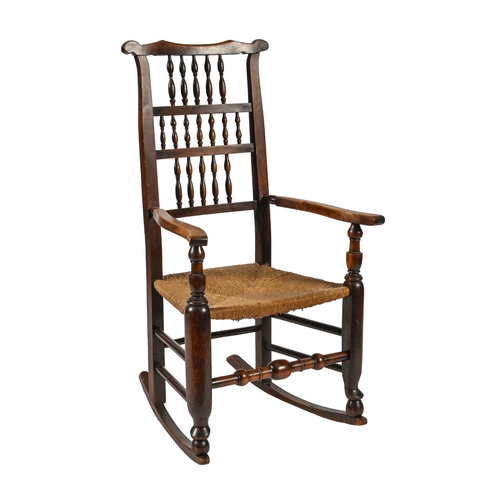 978 - A Victorian ash spindle back rocking elbow chair, rush seated