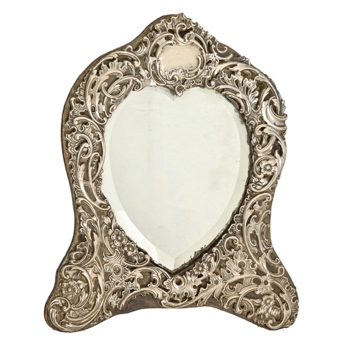 317 - An Edwardian silver heart-shaped dressing mirror, the mount die stamped with flowers and scrolls, 30... 