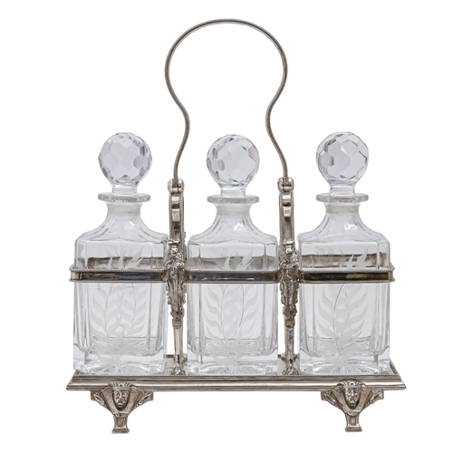 324 - An EPNS tantalus, with swing handle and set of three cut and engraved glass decanters and stoppers, ... 