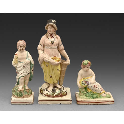 298 - A Staffordshire pearlware figure of a reclining boy and another holding a cockerel, c1790-1800, in c... 