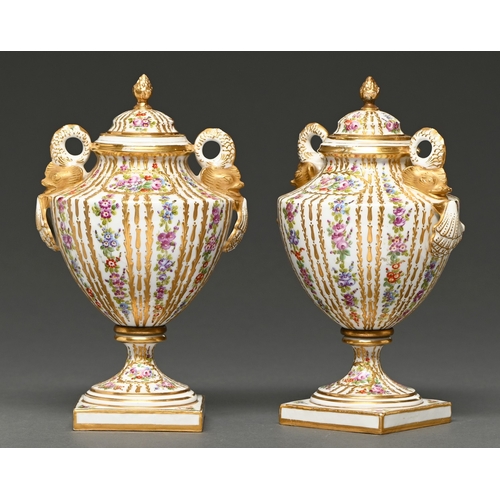 301 - A pair of continental gilt porcelain urns and covers, c1900, with twin ring handles in the form of d... 