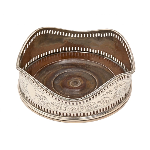 10 - A George III neo classical pierced and engraved silver wine coaster, with undulating beaded rim, ins... 