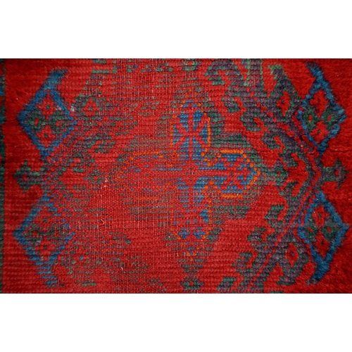 162 - A Turkish Ushak tomato red long rug, early 20th c, 90 x 254cm