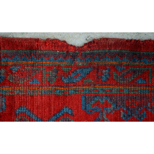 162 - A Turkish Ushak tomato red long rug, early 20th c, 90 x 254cm