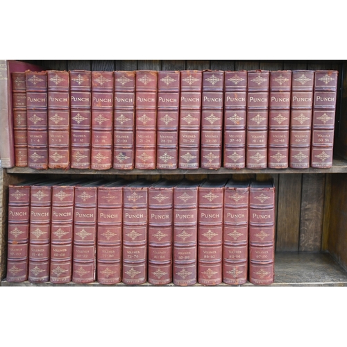 210 - Antiquarian Books. Twenty-six Punch annuals, mid 19th c and later, uniformly bound in red quarter-ro... 