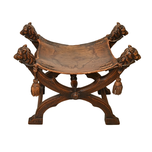 334 - An 18th c style carved oak X-frame stool, the leather seat supported by four brass rings and carved ... 