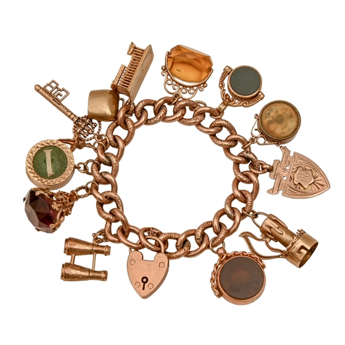 109 - A gold charm bracelet, with padlock and a collection of gold charms, including binoculars, candlesti... 