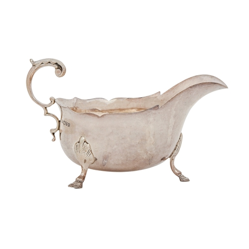 176 - An Edwardian silver sauceboat, with flying scroll handle, on hoof feet, 17cm l, by Nathan & Haye... 
