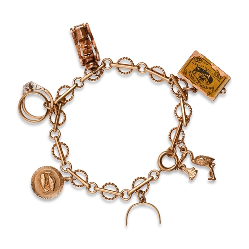 5 - A gold charm bracelet, with a collection of gold charms, including vintage motor car, matchbox and s... 