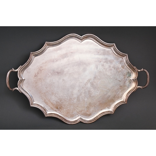 277 - An Edwardian silver tea tray, 56.5cm over handles, London 1905, shaped oval, by C S Harris & Son... 