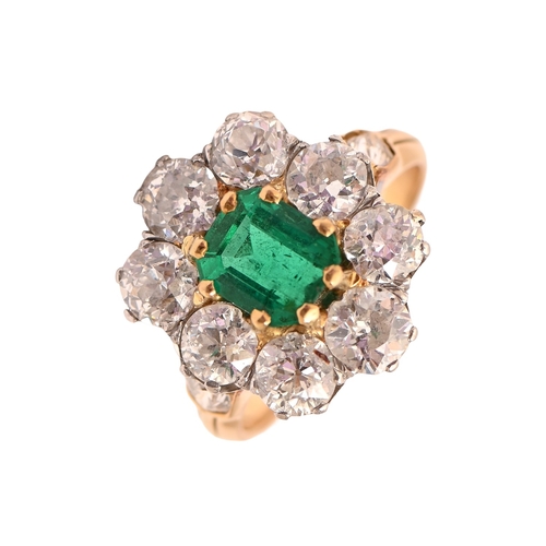 54 - An emerald and diamond ring, the step cut emerald of approx 4.1ct in a surround of eight old cut dia... 