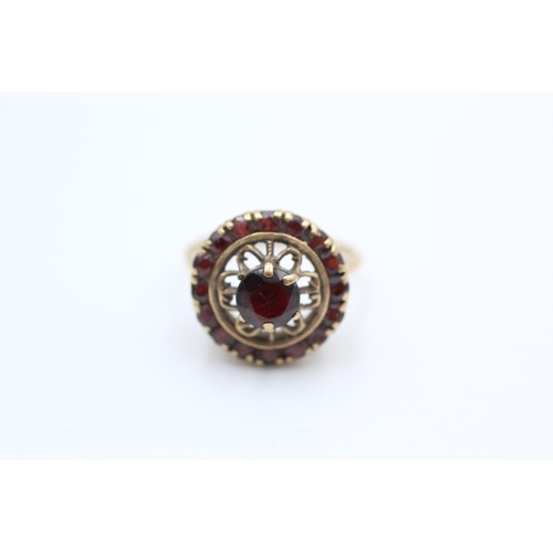 106 - 9ct gold ornate garnet target ring size M