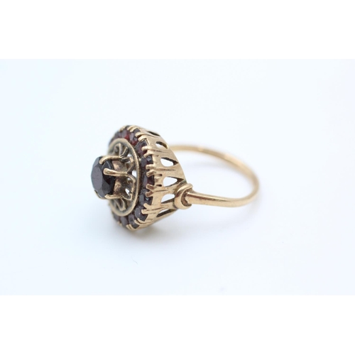 106 - 9ct gold ornate garnet target ring size M