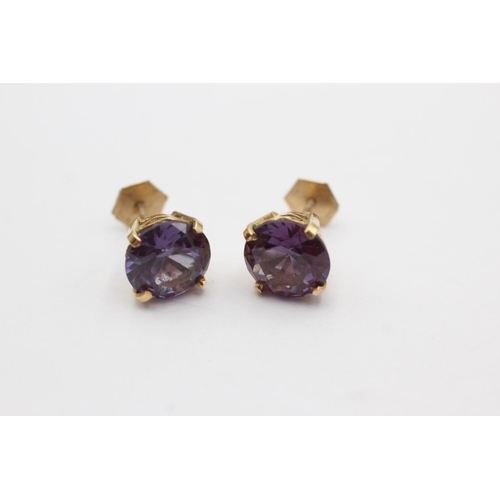 257 - 18ct gold synthetic colour changing sapphire earrings (4.1g)