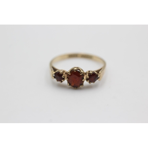 110 - 9ct gold garnet trilogy ring (1.6g)  Size M