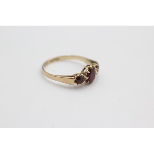 110 - 9ct gold garnet trilogy ring (1.6g)  Size M