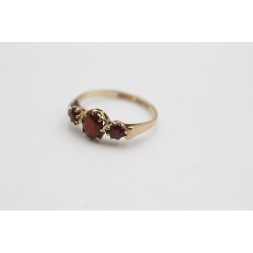 110 - 9ct gold garnet trilogy ring (1.6g)  Size M