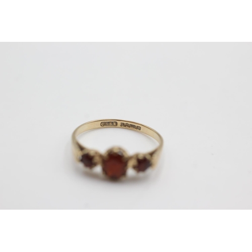 110 - 9ct gold garnet trilogy ring (1.6g)  Size M