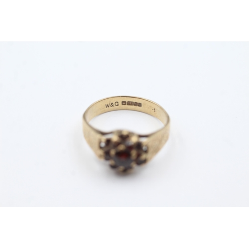 199 - 9ct gold textured band floral garnet set ring (2.5g)  Size  M