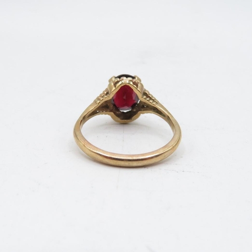 70 - 9ct gold garnet solitaire ring with textured frame (2.9g) Size   O