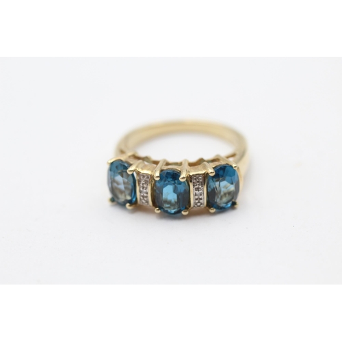 134 - 9ct Gold Blue Topaz Three Stone Ring With Diamond Spacers (4g) Size N