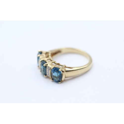 134 - 9ct Gold Blue Topaz Three Stone Ring With Diamond Spacers (4g) Size N