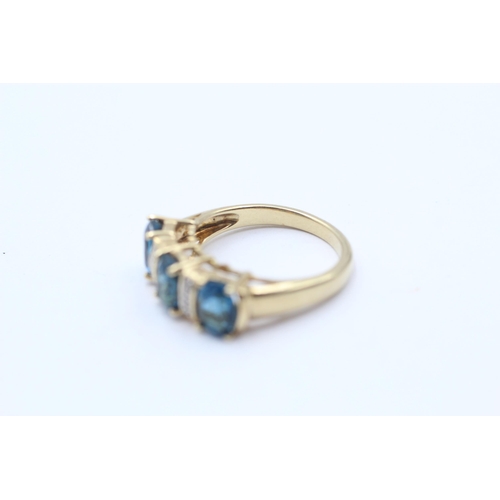 134 - 9ct Gold Blue Topaz Three Stone Ring With Diamond Spacers (4g) Size N