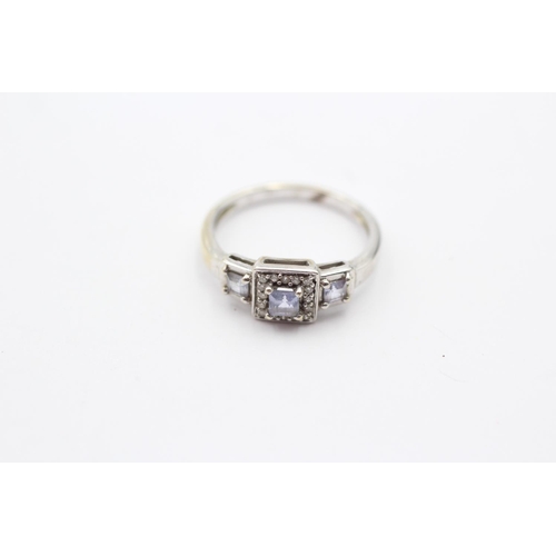 55 - 9ct White Gold Tanzanite Three Stone Ring With Diamond Surround (2.1g) Size  K