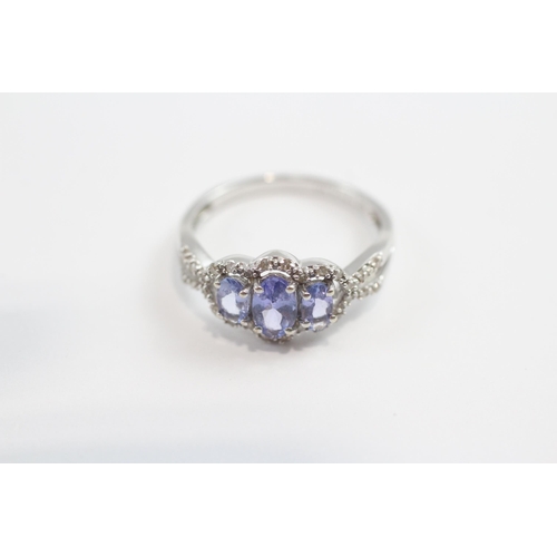 93 - 9ct White Gold Tanzanite Three Stone Ring With Diamond Frame (1.9g) Size  M