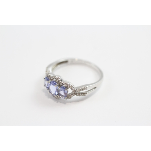 93 - 9ct White Gold Tanzanite Three Stone Ring With Diamond Frame (1.9g) Size  M