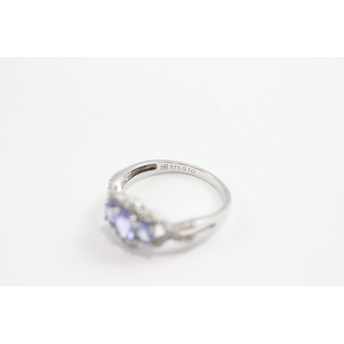 93 - 9ct White Gold Tanzanite Three Stone Ring With Diamond Frame (1.9g) Size  M