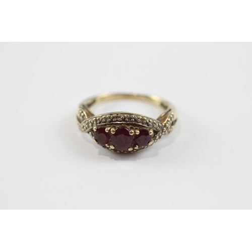 103 - 9ct Gold Ruby Three Stone Ring With Diamond Frame (2.9g) Size  O