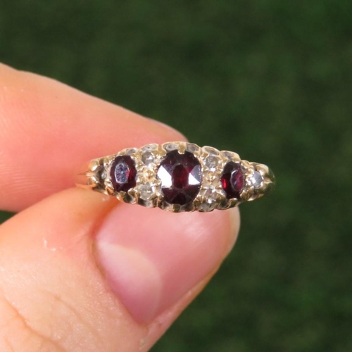 111 - 9ct Gold Diamond & Garnet Seven Stone Ring (3.5g) Size  M