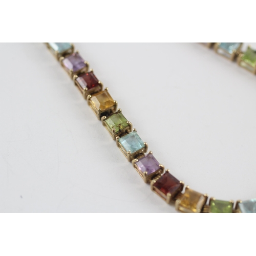 218 - 9ct gold amethyst, topaz, peridot, citrine & garnet tennis bracelet (7.4g)