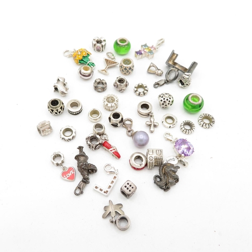 209 - A collection of silver mixed brand charms (97g)