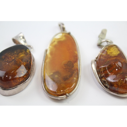 184 - Four silver Amber pendants including Baltic