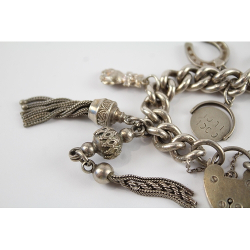 196 - Silver charm bracelet including antique watch chain tassels