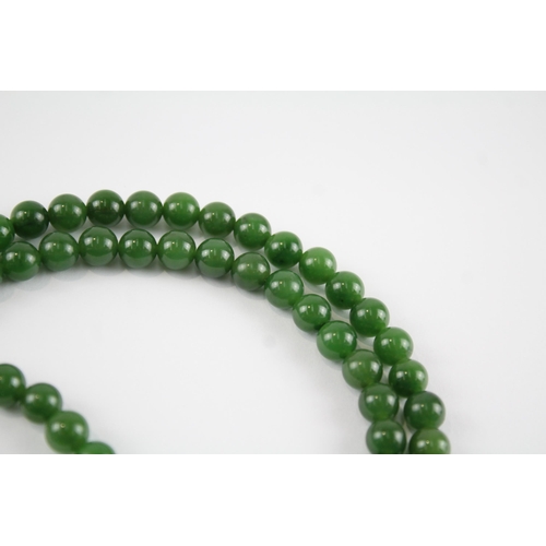 59 - 14ct gold clasp & bail nephrite single strand necklace with a carved pendant (84.1g)