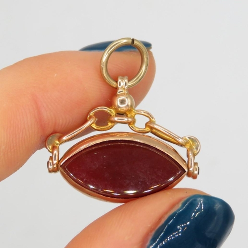 109 - 9ct gold vintage carnelian and onyx set marquise shaped spinning fob (3.3g)