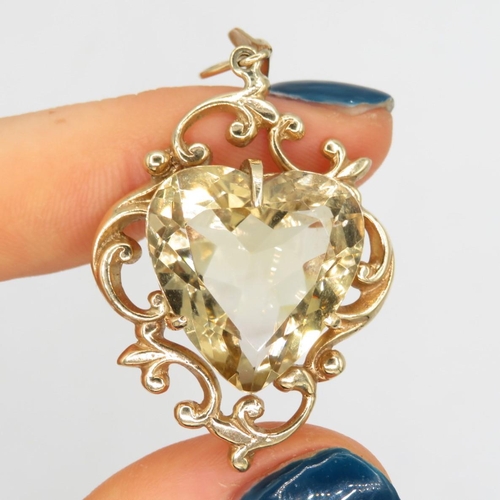 149 - 9ct gold citrine heart pendant with scrolling frame (8.6g)