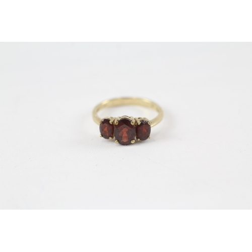 29 - 9ct gold garnet three stone ring (2.8g) Size  P+1/2