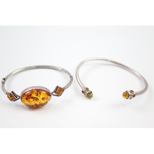 221 - Two sterling silver amber bangle bracelets (25g)