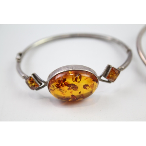 221 - Two sterling silver amber bangle bracelets (25g)