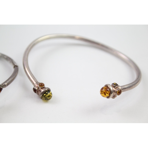 221 - Two sterling silver amber bangle bracelets (25g)